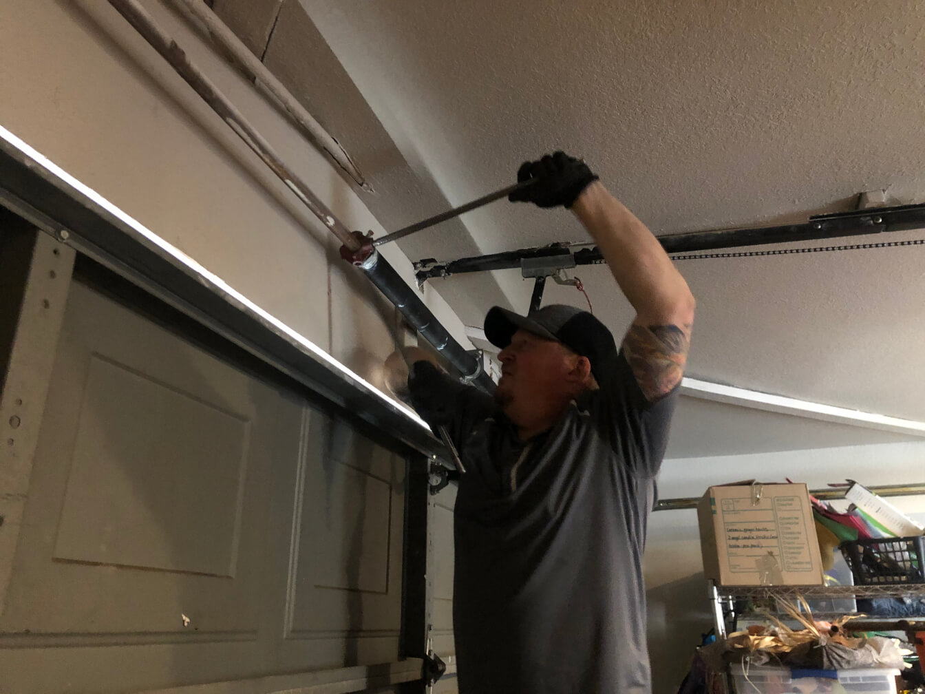 Image of a service technician installing a new garage spring.